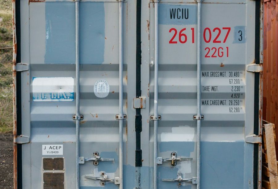 Grey shipping container doors on a dirt lot